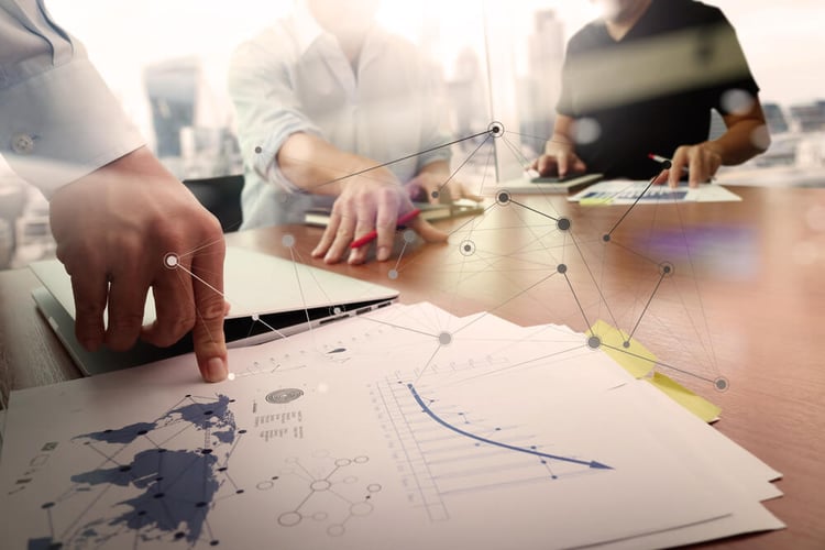 business documents on office table with smart phone and laptop computer and graph financial with social network diagram and two colleagues discussing data in the background_seo-opt