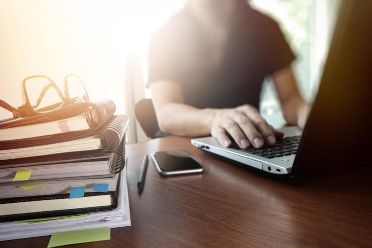 designer hand working with  digital tablet and laptop and notebook stack and eye glass on wooden desk in office_seo-opt